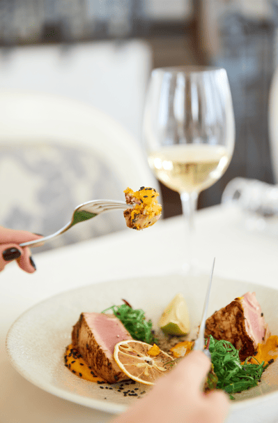 Copa de vino blanco junto a un solomillo